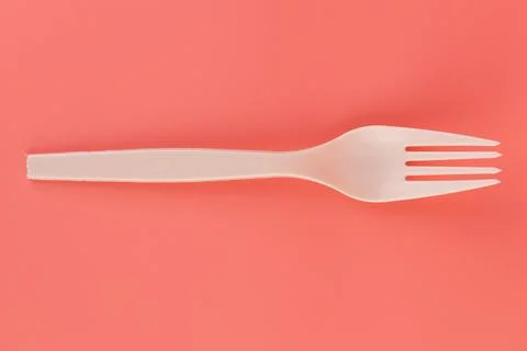 Soft pink background pair of plastic white forks disposable tableware eco Stock Photos