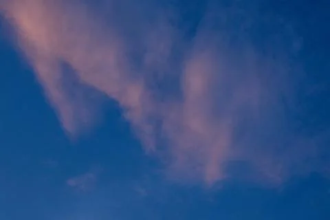 Soft Pink Clouds Against Deep Blue Sky Foto stock