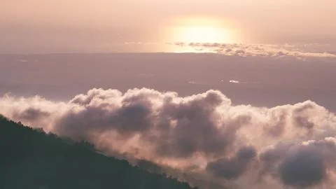 Soft pink clouds drift over distant sunset horizons above the Georgian mounta Stock Photos