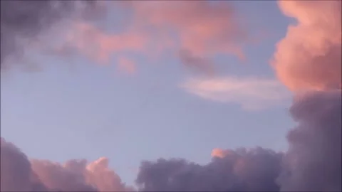 Soft Pink Clouds at Sunset against a blue sky Stock Footage 232069732