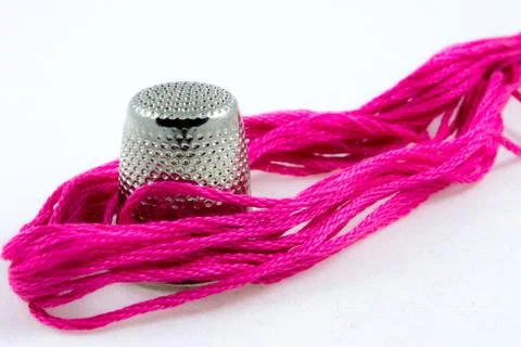 Soft pink cotton thread and a thimble Foto stock