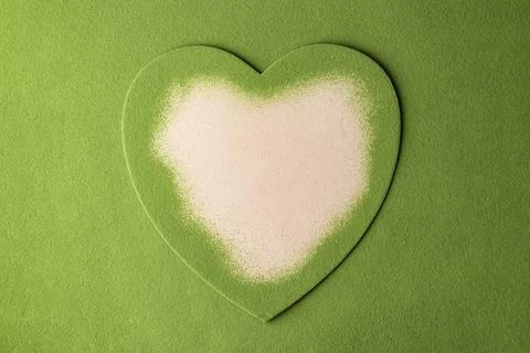 Soft pink heart appears inside a green matcha dust layer, inviting messages o Stock Photos