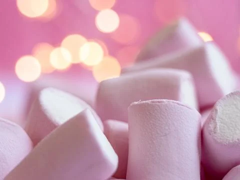Soft pink marshmallows stacked casually on light surface, creating warm and.. Stock Photos