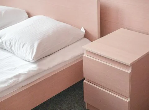 Soft pink tinting, close-up of the bed and bedside table, modern interior of the Stock Photos