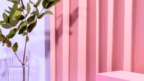 Soft pink vertical ribbed background with green plant Stock Photos