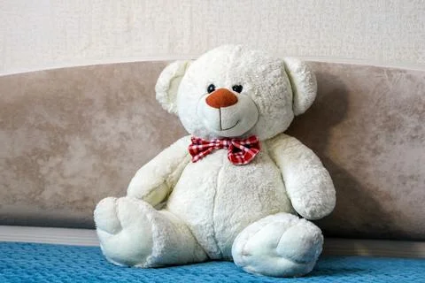 Soft plush teddy bear placed on bed in home bedroom interior, symbol of chi.. 스톡 사진