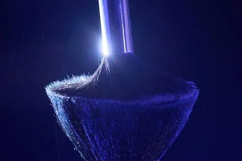 Soft powder mist gently settling on brush bristles, fine particles drifting i Stock Photos
