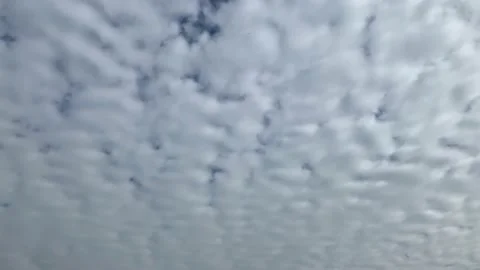 Soft, puffy layer clouds clearing to reveal a blue sky Stock Footage 147076295