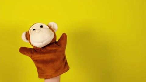 Soft puppet toy on hand on yellow background. Concept of puppet show. Close-up Stock Footage 156481477