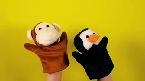 Soft puppet toys on hands on yellow background. Concept of puppet show. Close-up Stock Footage 156481372