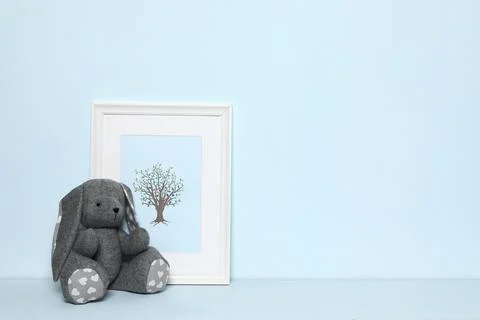 Soft rabbit and picture on white background, space for text. Child room inter Stock Photos
