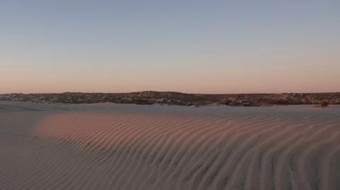 Soft rays of sunlight visible on pattern of sand dune ripples Foto stock