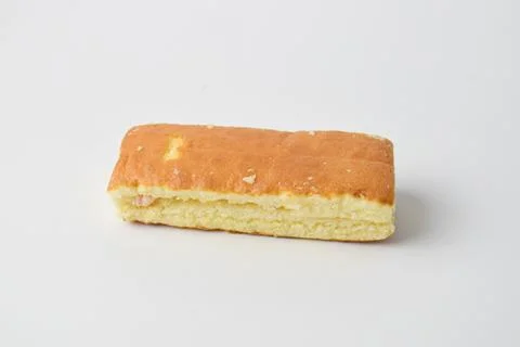 Soft rectangular sponge cake with filling on white background, minimal clos.. Stock Photos