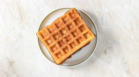 Soft rectangular Viennese waffles on a saucer. Delicious dessert. Stock Photos