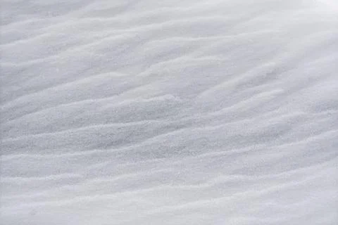 Soft rippled snow surface forming gentle natural texture under diffused winte Stock Photos