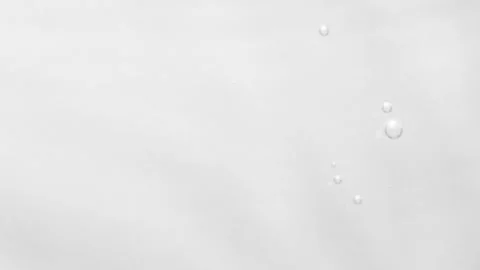 Soft ripples and floating air bubbles on a clean light gray surface Stock Footage 314584816