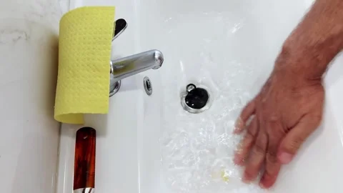 Soft Ripples Retreat: A Pause in the Flow of Daily Sink Ritual Stock Footage 313863158