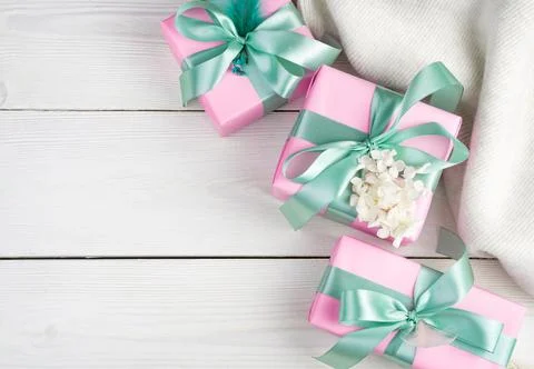 Soft romantic background with gift boxes and a white sweater on a light wooden Stock Photos