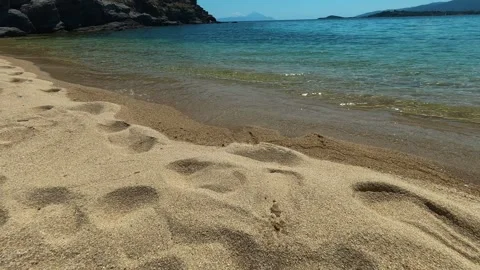 Soft sand marks trail toward calm turquoise water. Trani Ammouda, Greece Stock Footage 339613887