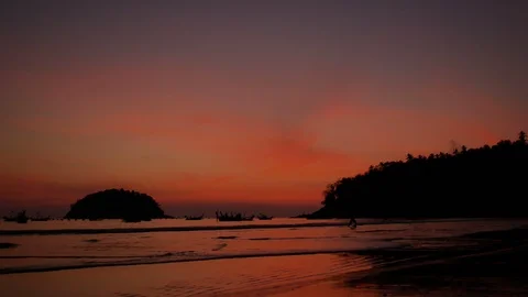 Soft sea wave breaking sand beach, silhouette tree mountain on right, island  Stock Footage 126755578
