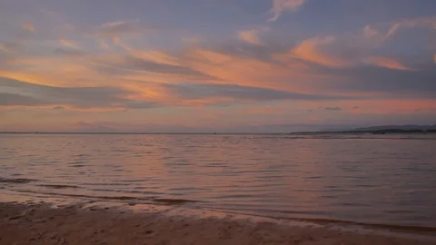 Soft sea wave breaking sand shore beach, silhouette mountain and island, clou Stock Footage 128298173
