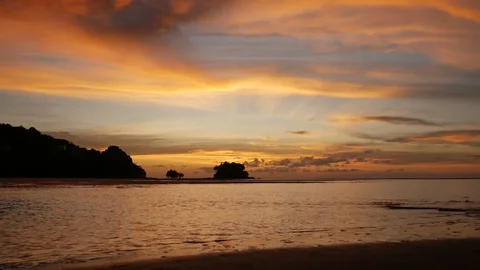 Soft sea wave breaking sand shore beach, silhouette mountain and island, clou Stock Footage 128298205