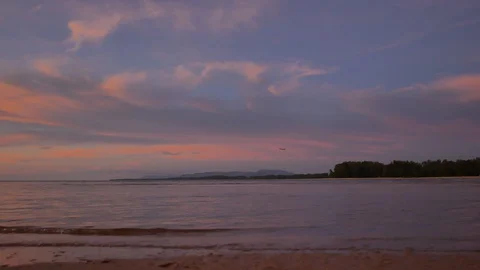Soft sea wave breaking sand shore beach, silhouette mountain and island, airp Stock Footage 128298292