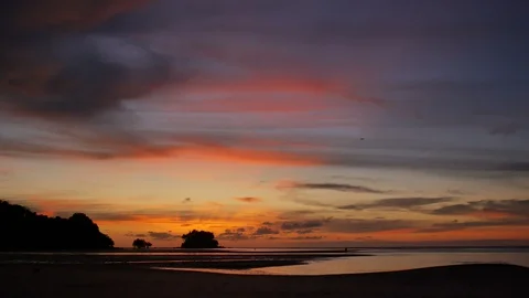 Soft sea wave breaking sand shore beach, silhouette mountain and island, airp Stock Footage 128299644
