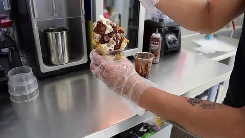 Soft serve ice cream machine waffle cone vanilla toppings with caramel Video stock 83965881