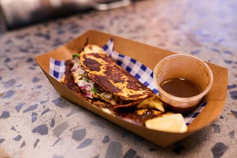 A soft shell taco ready for takeaway in a recyclable container at a market Stock Photos