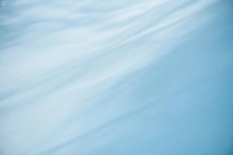 Soft snow surface presenting gentle waves and subtle shadows, creating an abs Stock Photos