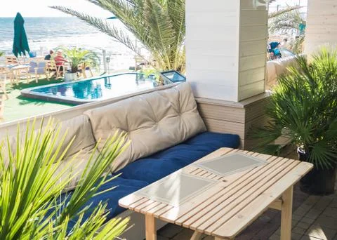 Soft sofa and table in an outdoor cafe with a pool Stock Photos