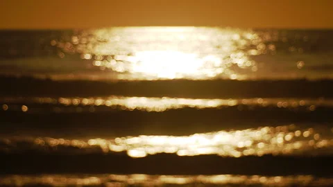 Soft, sparkling ocean waves rolling onto the shore at sunset. Stock Footage 345502264