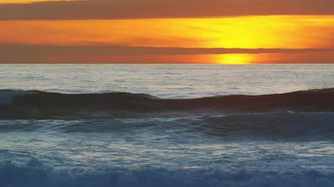 Soft, sparkling ocean waves rolling onto the shore at sunset. Stock Footage 345502333
