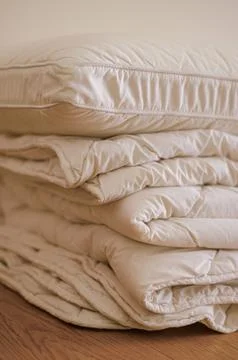 Soft stack folded blanket and pillows on the wooded floor in room Stock Photos