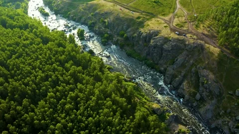 Soft sun rays in evening over a beautiful valley with a mountain river and many Video stock 133169391