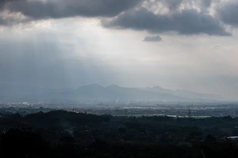 Soft sunlight breaks through cloudy skies in West Java, Indonesia. 库存照片