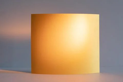 Soft sunlight casts a warm glow on a curved piece of golden yellow orange pap Stock Photos