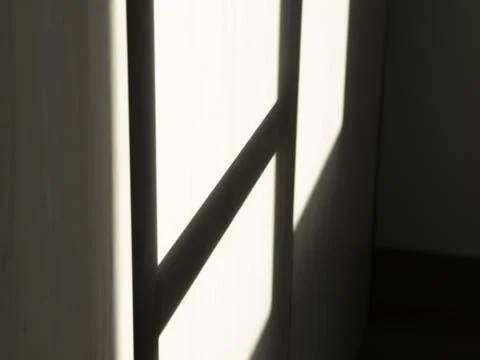 Soft sunlight filters through a window frame Stock Photos
