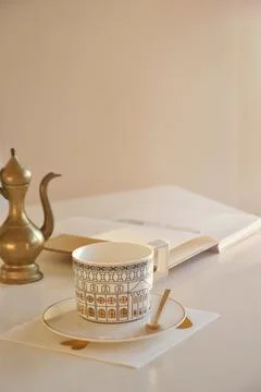 Soft sunlight shines on a white table with coffee cup and an empty planner Stock Photos