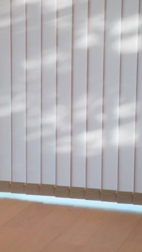 Soft sunlight through white vertical blinds in modern home interior video Stock Footage 333236710