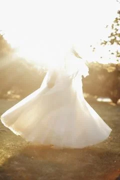 Soft sunlight wraps around a flowing white gown Foto stock