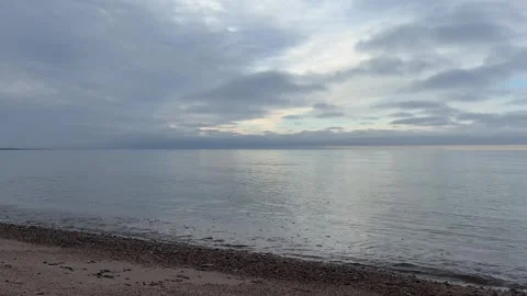 Soft Sunset Light Over Calm Baltic Sea Waves Through Clouds in 4K with Sound Stock Footage 323010194