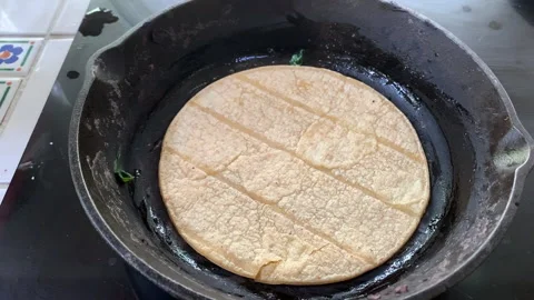 Soft Taco Shell begins to cook on a pan or skillet on hot oven top Stock Footage 131105067