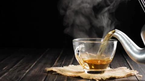 Soft tea cup focus Pour hot tea into the teacups placed on the table in slow mot Stock Footage 201917047