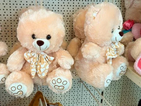 Soft teddy bears with bow on retail shelf. Childhood comfort, gift idea, inno Stock Photos