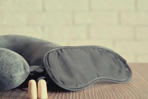 Soft toned image with a set of sleeping equipment including eye mask and pillow Stock Photos