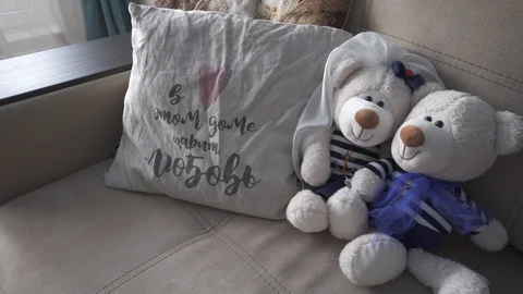 Soft toys of a bear lie on a sofa with pillows Stock Footage 119367528