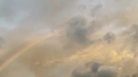 Soft twilight sky with a fading rainbow among gentle clouds. Stock Footage 326219143