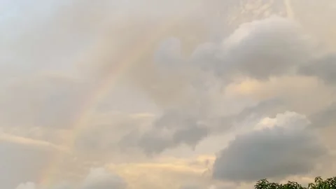 Soft twilight sky with a fading rainbow among gentle clouds. Stock Footage 326219147